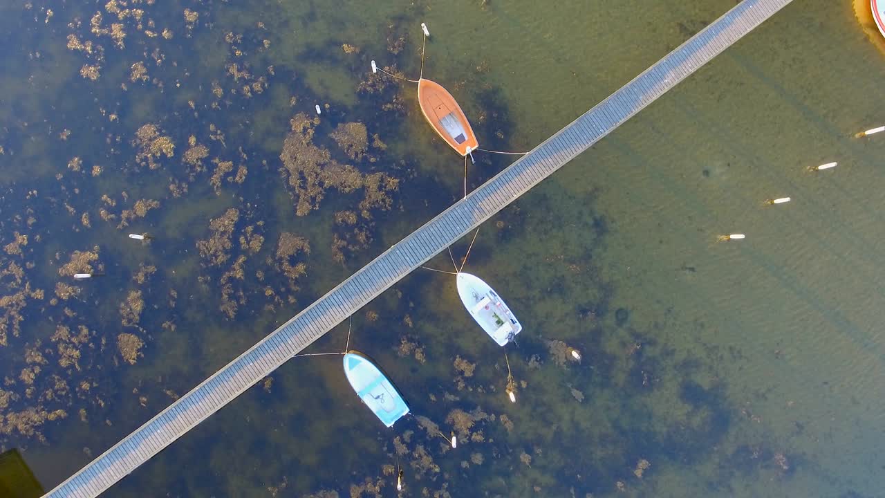 Aerial spinning view of a Wooden pier with attached boats