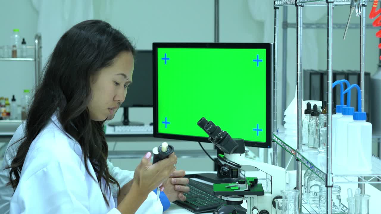 Scientist working in modern laboratory or medical center. Background monitor green screen. Concept of science, testing development and lab industry.