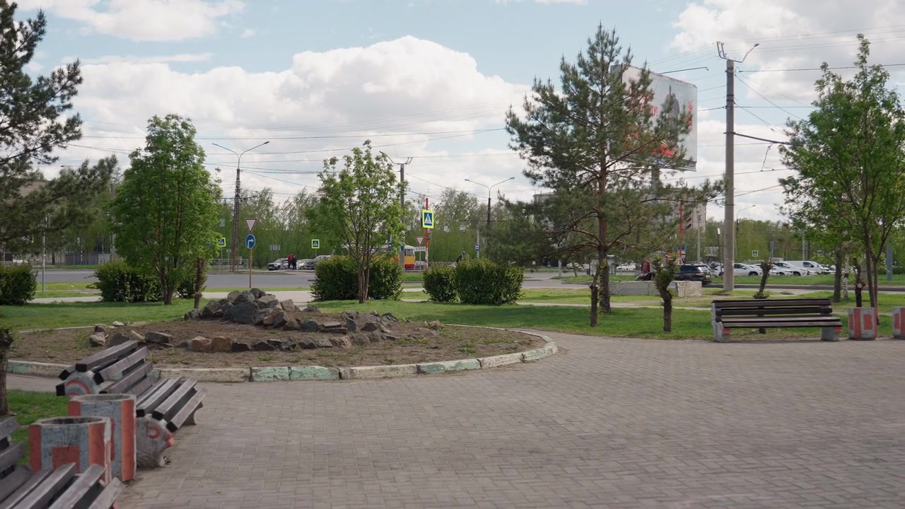 Parc urbain tranquille avec des bancs et des arbres verts par une journée nuageuse