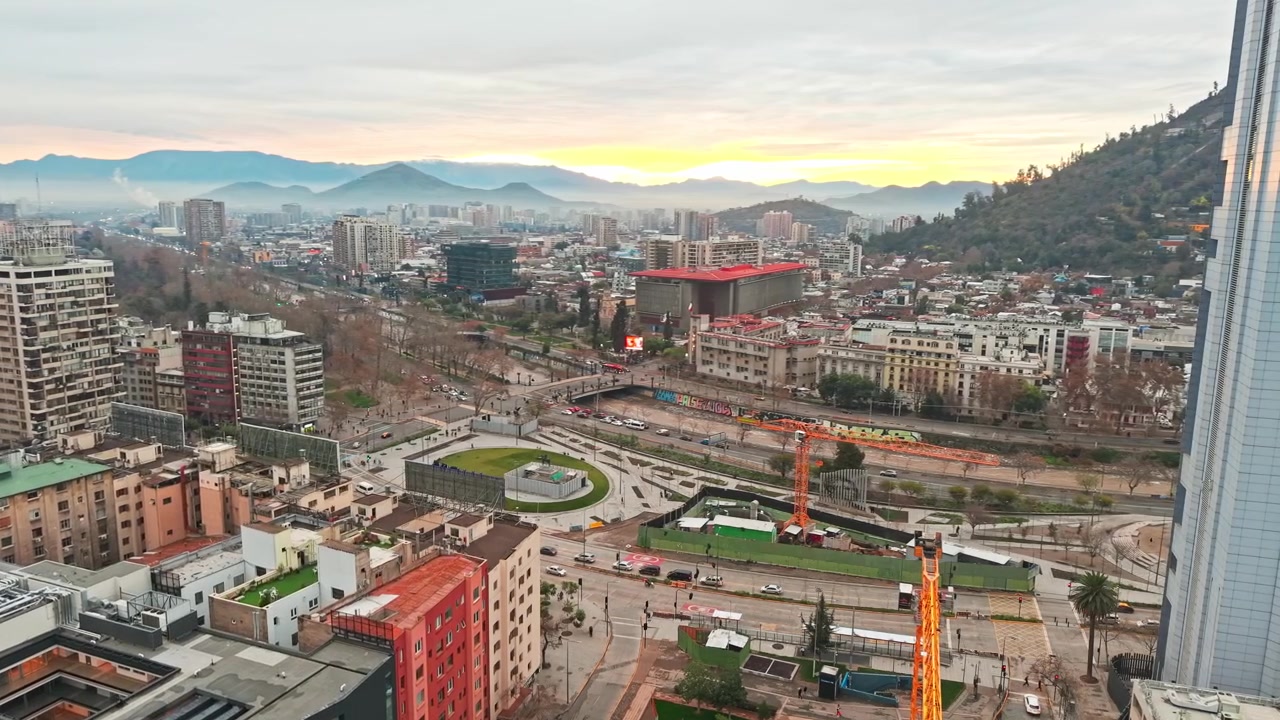 Orbita aerea panoramica di Piazza Baquedano con macchinari da costruzione nel centro di Santiago, Cile, in un pomeriggio nuvoloso