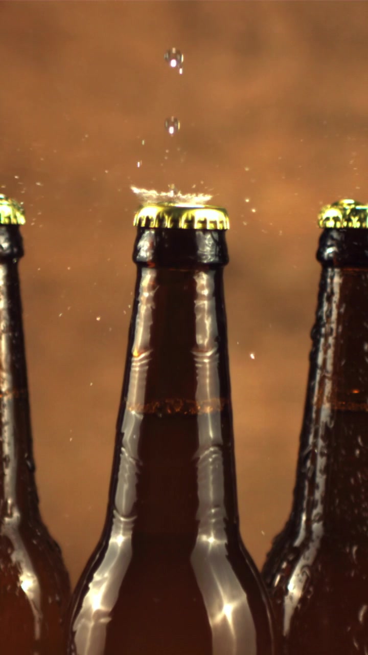Wassertropfen spritzen in Zeitlupe auf einen kalten Bier-Kronkorken
