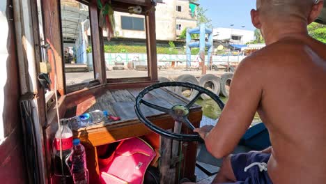 man navigating boat on a canal in city