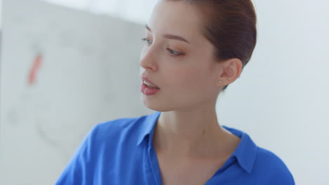 woman face looking white board indoors. business coach hand pointing flip chart