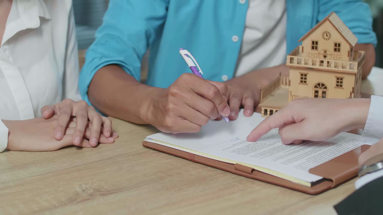 pareja firmando un contrato de bienes raíces