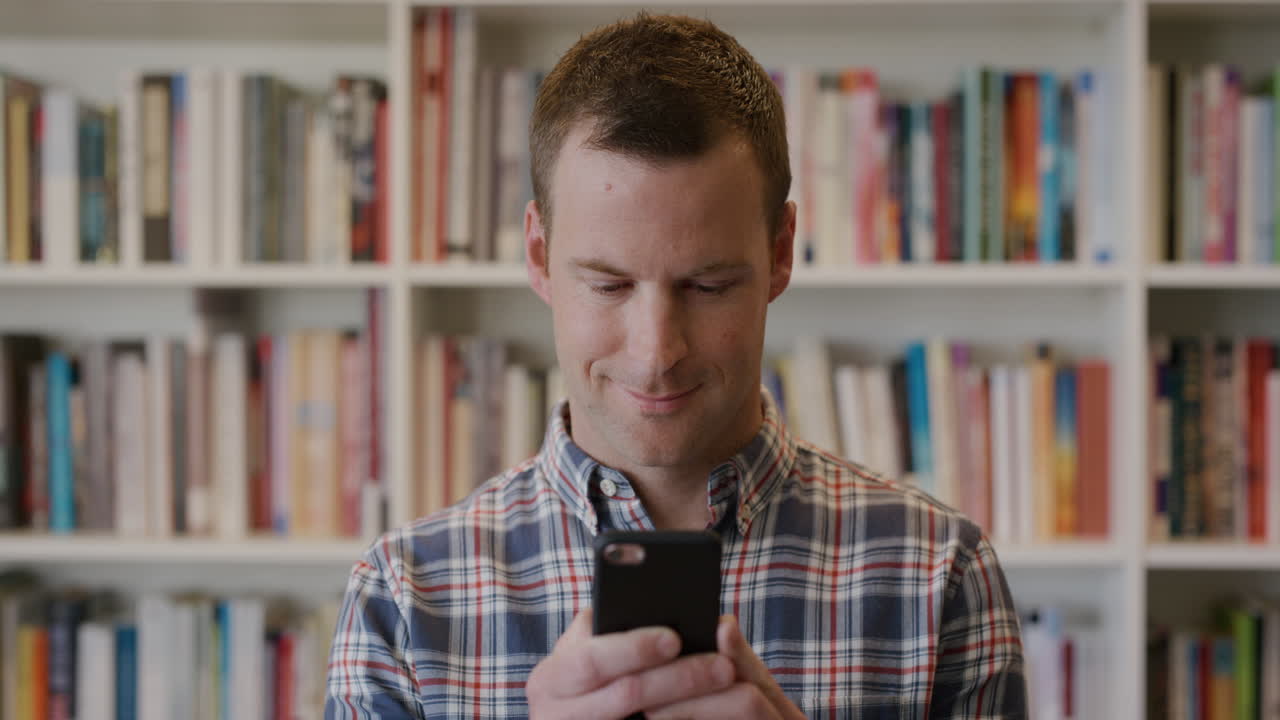 retrato de un joven emprendedor feliz que usa un teléfono inteligente, envía mensajes de texto, navega en línea, disfruta de enviar mensajes en cámara lenta en su teléfono móvil