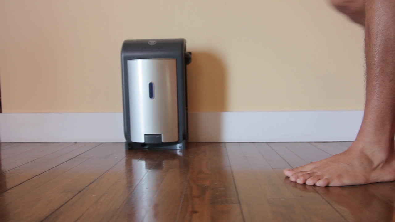 un hombre vestido solo con su ropa interior camina por un piso de madera y entra al vestidor