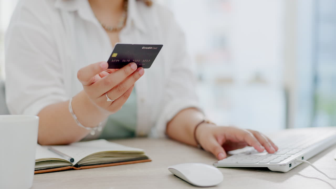 Mani di donna, carta di credito e computer per acquisti online