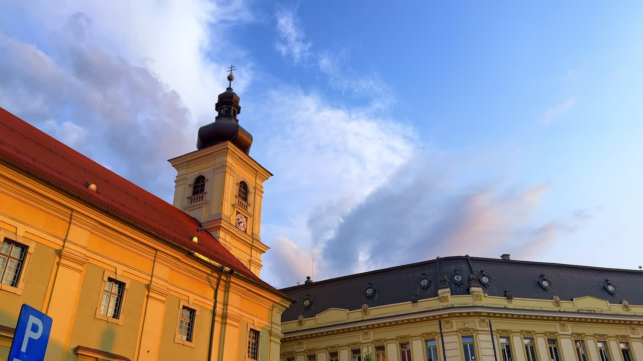 Clock tower in Sibiu old town. The Council Tower of Sibiu stands tall with its clock face lit by golden evening light