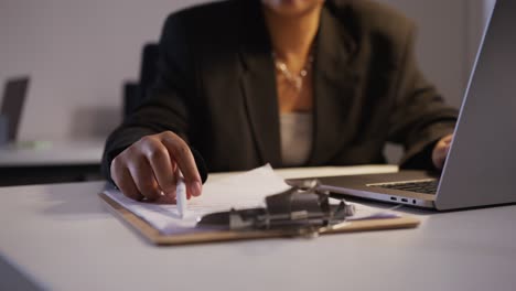 mujer llenando documentos en la oficina