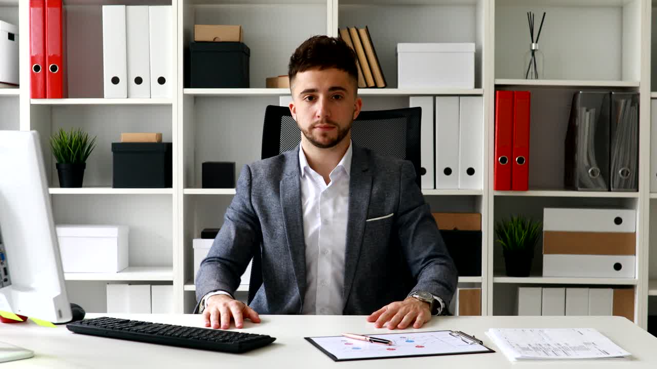 uomo d'affari sul posto di lavoro che guarda la telecamera