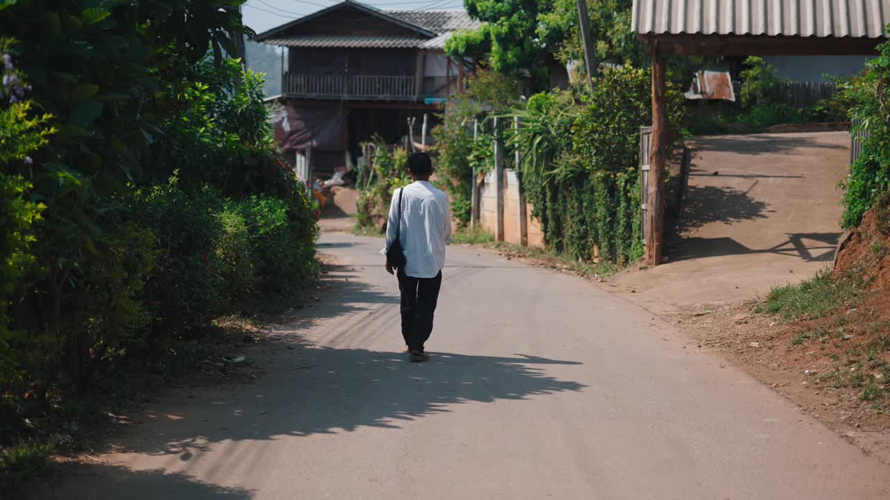 A person walking on a road in a rural village