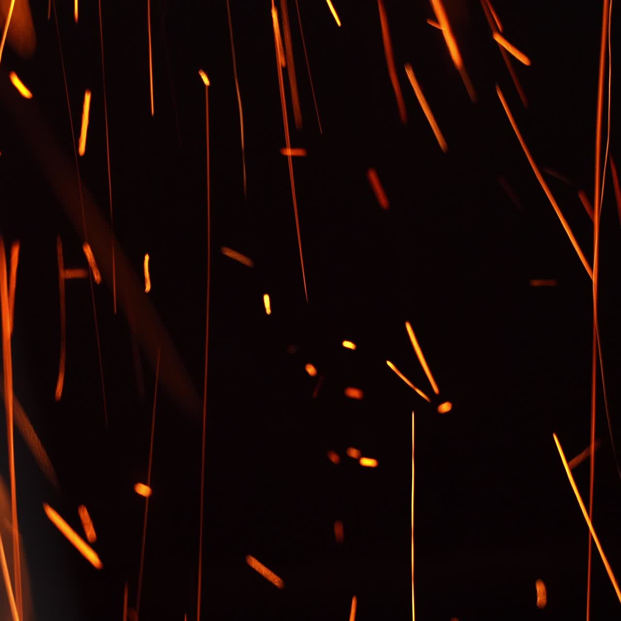 Long shining sparkles flying in changing direction. Beautiful bright scintilla moving quickly at black backdrop