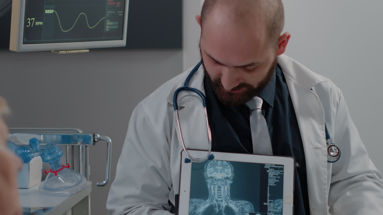 Doctor showing tablet with radiography for sick woman in bed