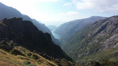 Majestic-view-from-Kiellandbu-Norway---Moving-forward-along-wooden-wall-of-old-traditional-hut-while-watching-brethtaking-landscape---Close-to-ground-aerial