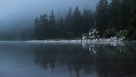 lake church in dolomite mountains on foggy day, time lapse view