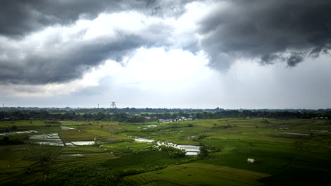 Timelapse-De-Hiperlapso-De-Nubes-Moviéndose-Sobre-Campos-De-Arroz-Verdes-En-El-Campo-Balinés,-Indonesia