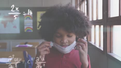 Animation-of-floating-mathematical-equations-over-girld-wearing-a-face-mask-sitting-in-a-classroom