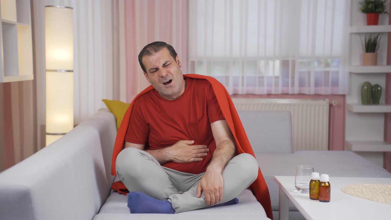 el hombre tiene dolor de estómago.