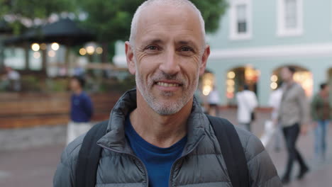 close up portrait of mature attractive caucasian tourist man looking at camera smiling urban background