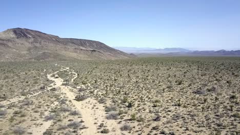 desierto peligroso, cielo sin nubes, montaña en el fondo audaz vista aérea vuelo volar hacia atrás imágenes de drones en el valle de coachella usa 2018