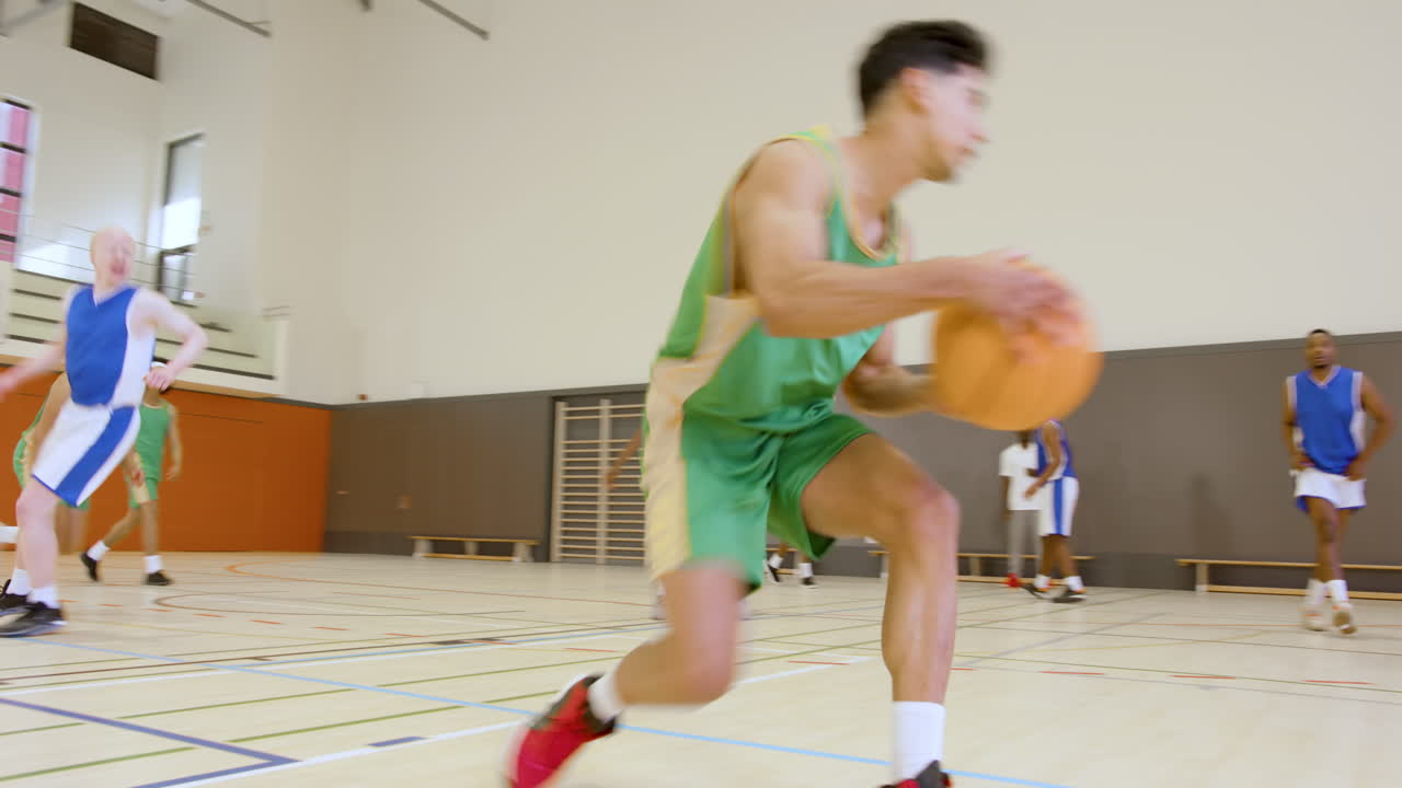 Basketball players in action on court, dribbling and competing intensely