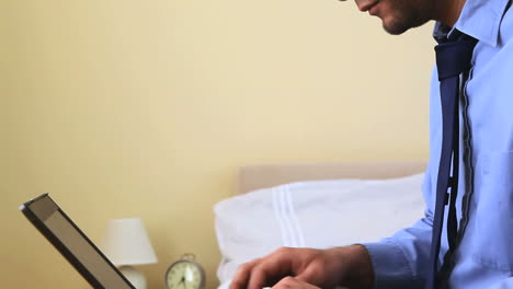 Businessman-typing-on-his-notebook-in-bed