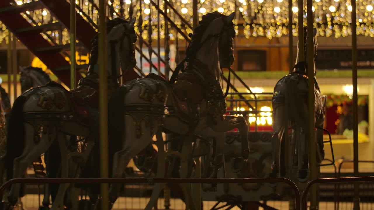 carrusel con caballos girando por la noche. atracción colorida para niños en el mercado de la ciudad. ocio, felicidad, diversión. cine 4k prores hq.