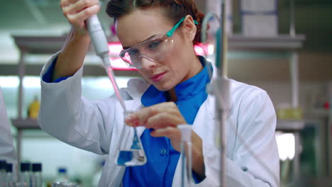 scientist woman working with chemical reagents. chemical reaction in lab flask