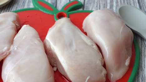 raw chicken breasts on a cutting board