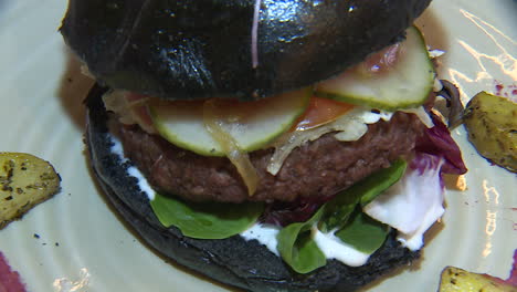 black bun vegan burger with roasted potatoes