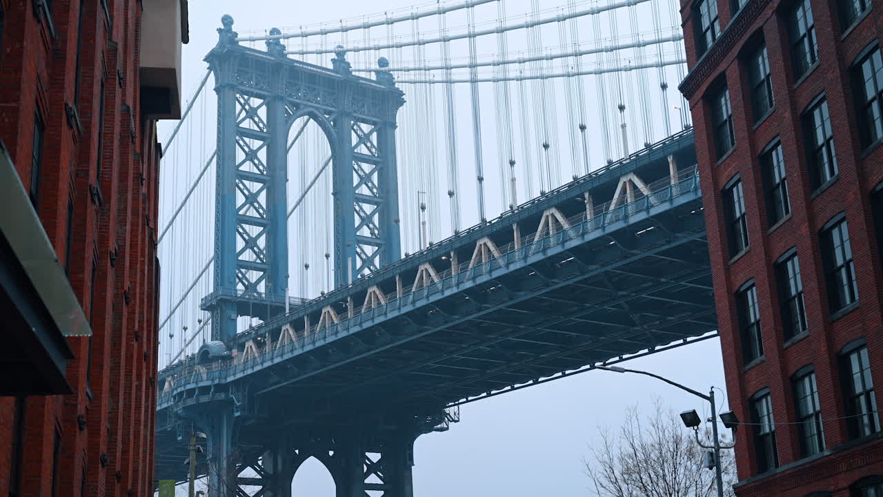 Manhattan Bridge og gatebilde fra DUMBO. Regntung gate i DUMBO, Brooklyn, med fotgjengere og Manhattan Bridge over murbygninger