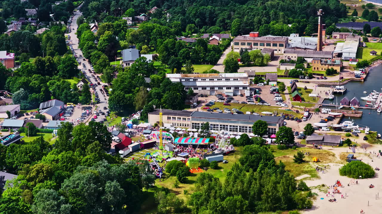 Lush green surroundings at Latvian festival with performances and crowd