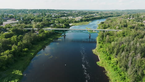 Luftaufnahme-Einer-Großen-Brücke-In-Der-Wunderschönen-Landschaft-Von-Maine-Mit-Dem-Fluss-Im-Vordergrund