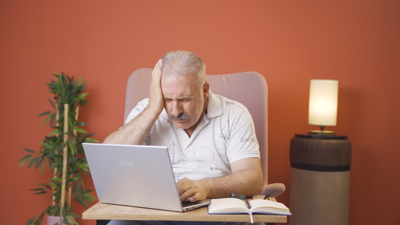 el viejo mirando la computadora portátil se frustra.