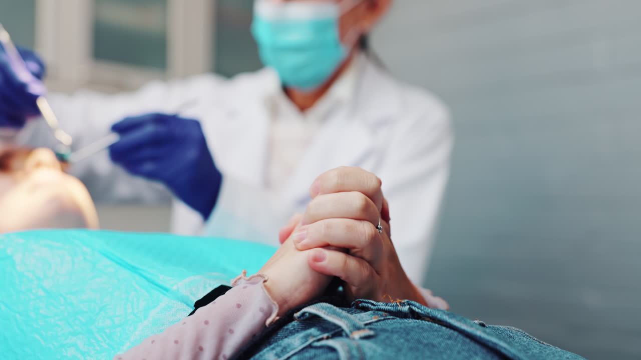 Dentista che rassicura il paziente durante la visita.