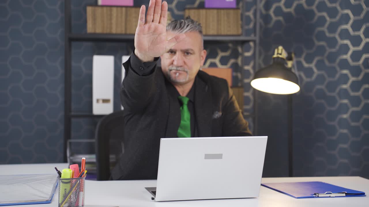 Businessman saying stop to camera.
