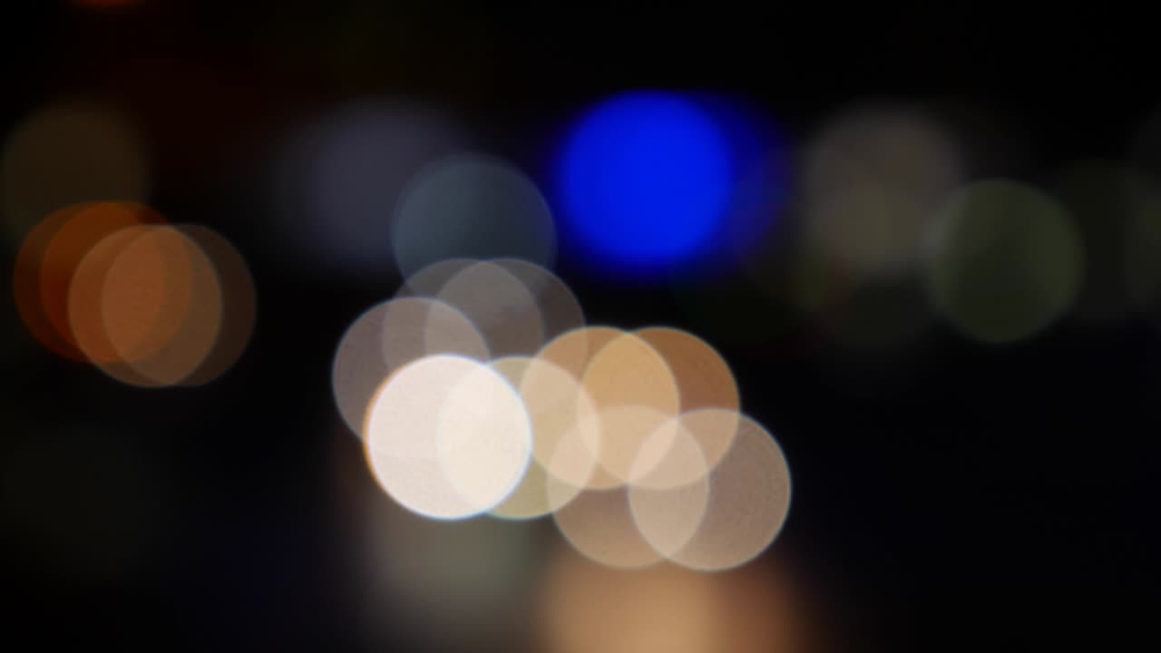 hermoso bokeh brillante en el fondo oscuro borroso por la noche. el redondo bokeh colorido brilla de las luces de los coches en la calle de la ciudad. fuera de foco con borroso. luces de la ciudad sin enfoque. bokeh de tráfico. concepto abstracto