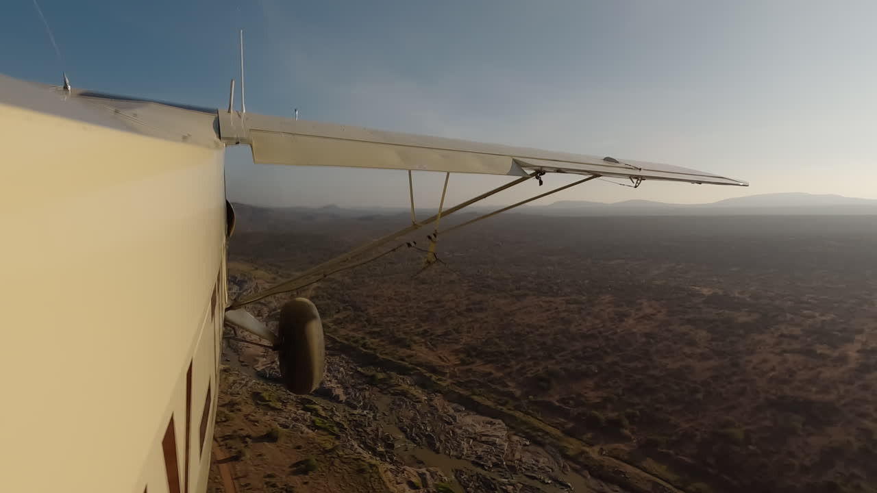 Small air plane side view over shrubs, river and road