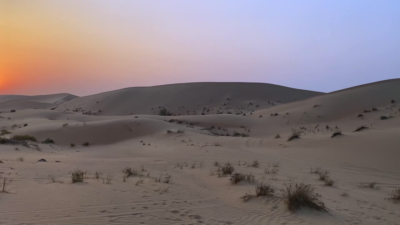 शांत रेगिस्तानी भूभाग पर स्वर्णिम सूर्योदय