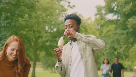 Una-Pareja-Joven-Viajando-Juntos-Por-La-Ciudad-Comiendo-Helados-En-El-Parque