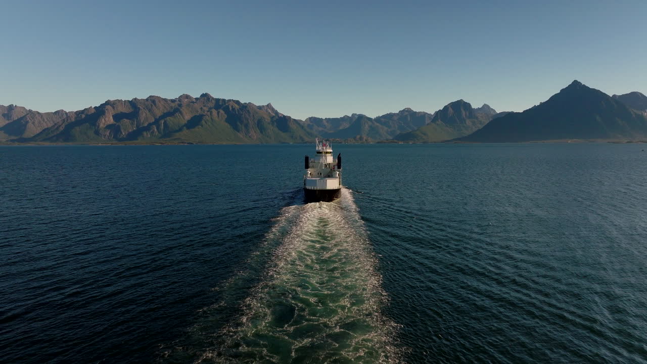 Drohnenaufnahme hinter der Fähre, die von Melbu nach Fiskebøl auf den Lofoten abfährt
