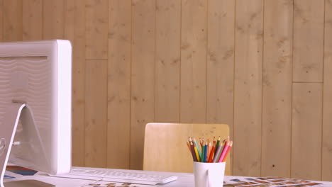escritorio con computadora y lápices de color