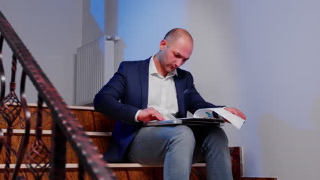 office manager reading raport sitting on stairs