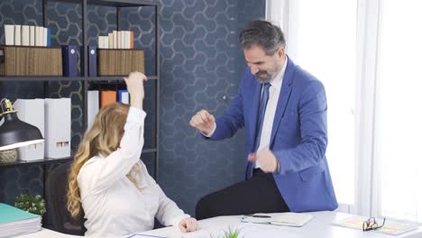 los empleados masculinos y femeninos que completan el trabajo en el proyecto están felices y celebrando.