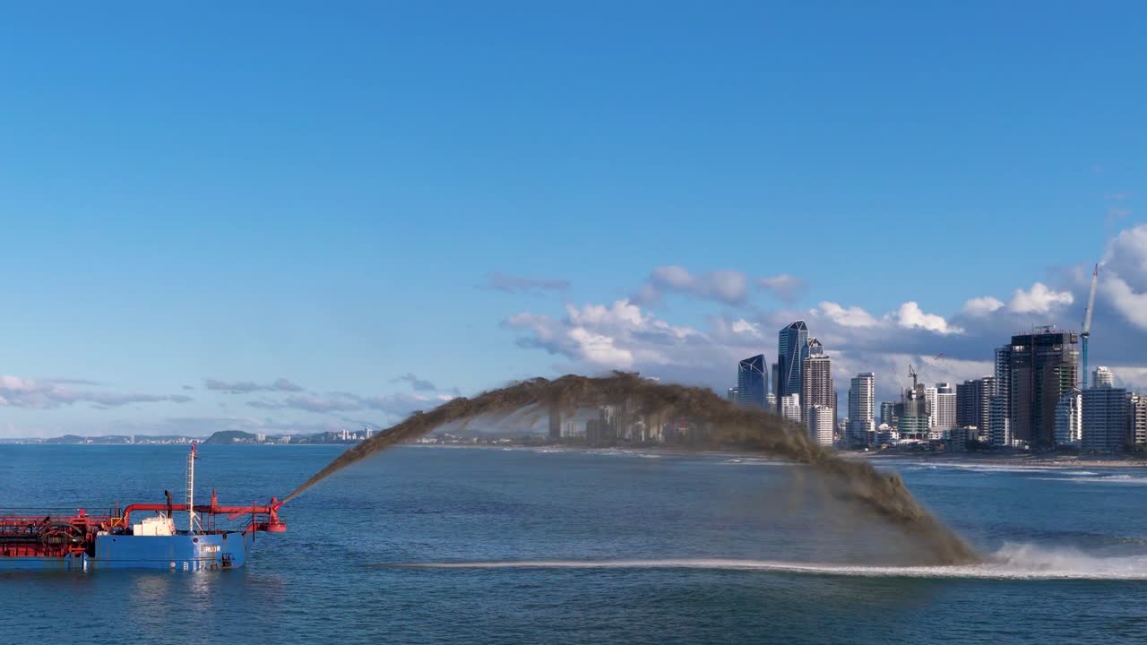 A dredging ship pumps sand to restore cyclone-damaged beaches in Gold Coast, Australia, under clear skies