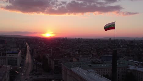 horizonte de sofia, bulgaria, bandera búlgara en el edificio del parlamento nacional al atardecer