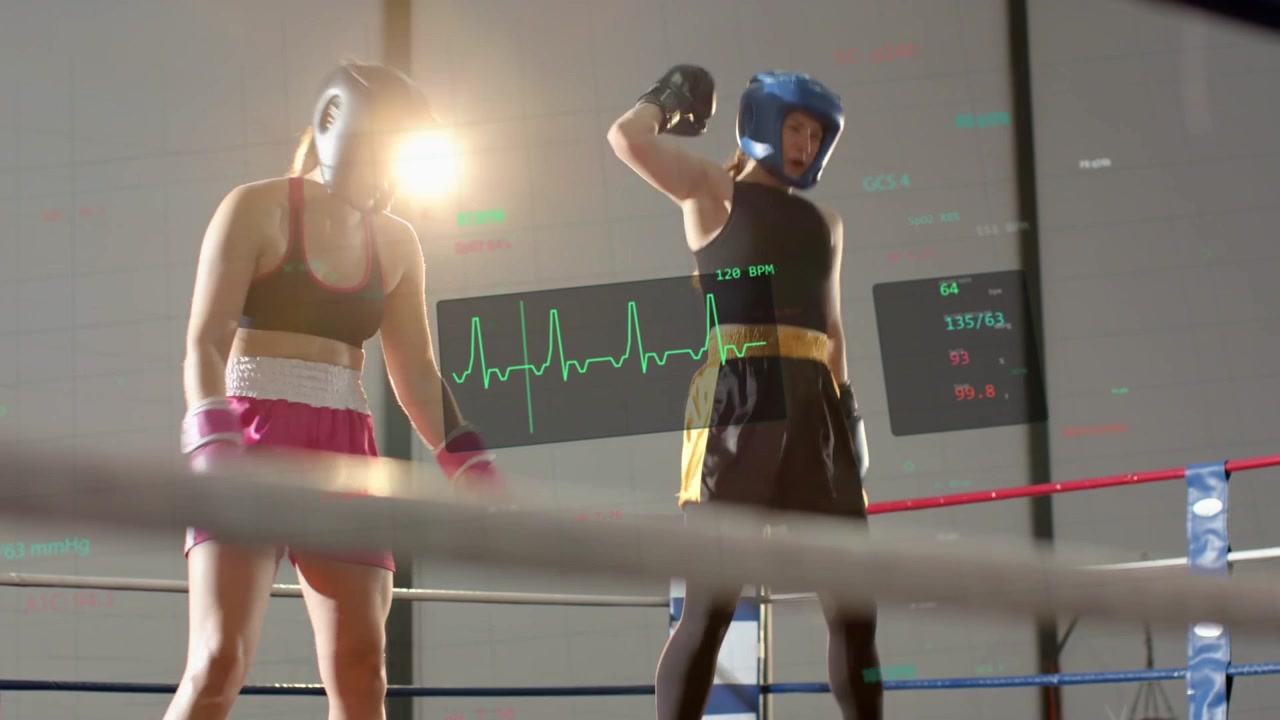Pugile blu che alza il braccio segnalando la vittoria, facendo entrare l'allenatore sul ring che alza il braccio, con un ECG dietro i combattenti.