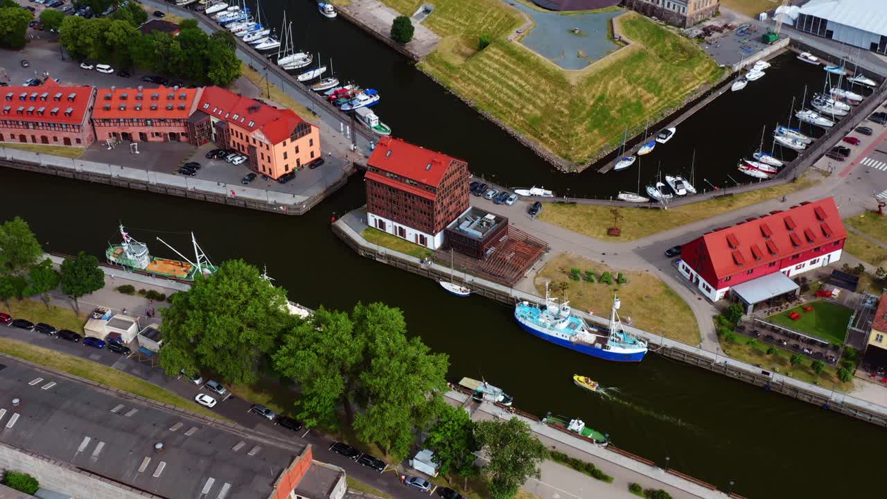 Top-down view of Port of Klaipeda canal with sailing boat and old buildings - Lithuania
