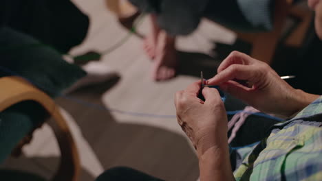 primer plano de manos de ancianos tejiendo