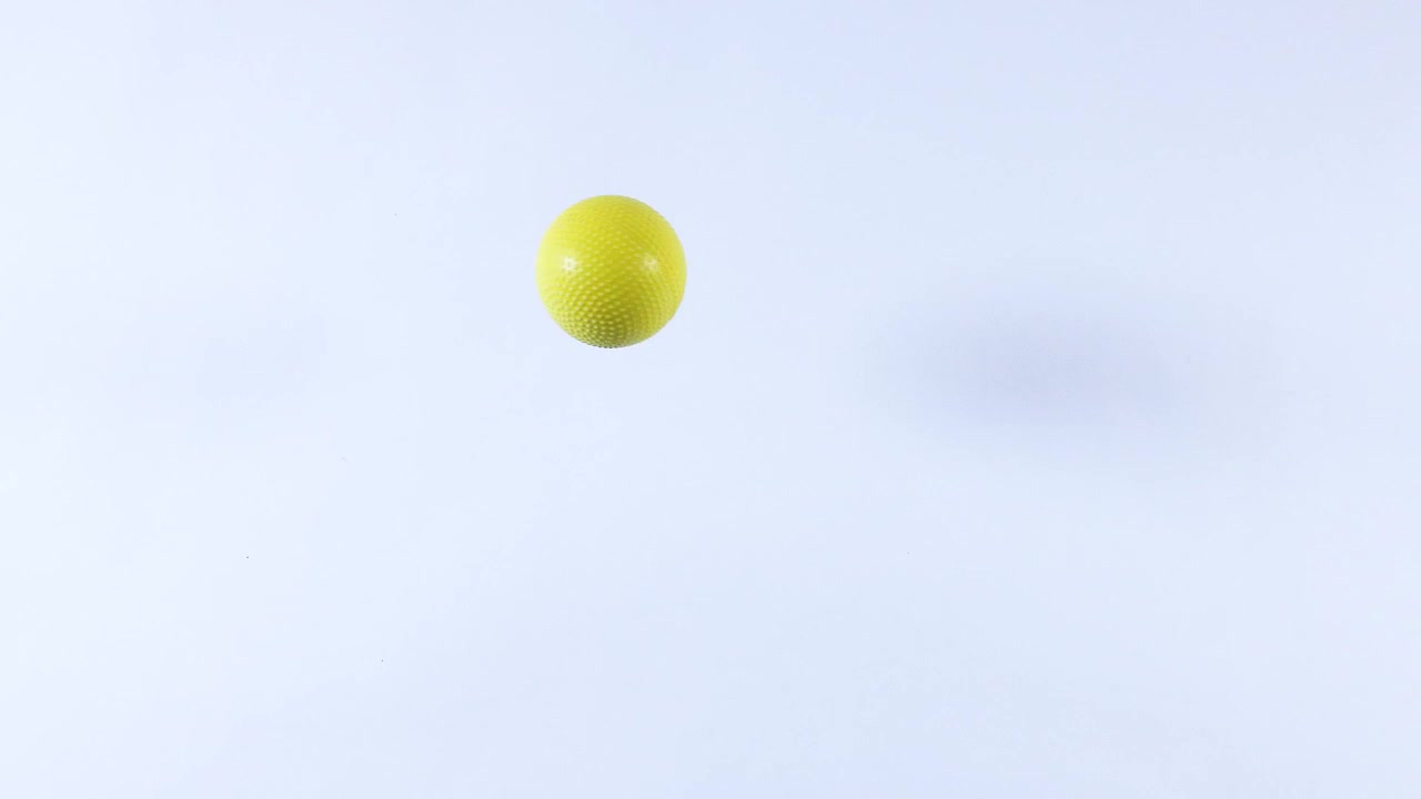 A yellow ball bounces against a white background